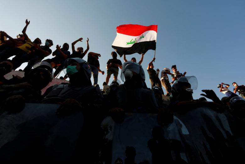 Iraqi protesters stand on concrete blast wall during a protest near the building of the government office in Basra, September 6, 2018.