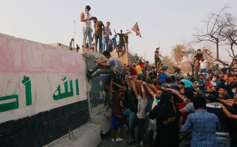 Protesters push down concrete blast walls of the government office building in Basra, September 5, 2018.