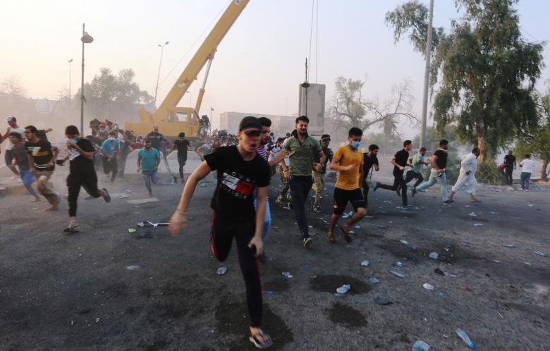 Iraqi protesters run during a protest near the building of the government office in Basra, September 5, 2018.