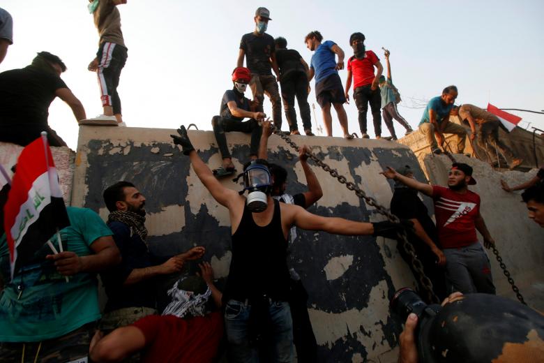 Protesters push down concrete blast walls for the building of the government office in Basra, September 5, 2018.