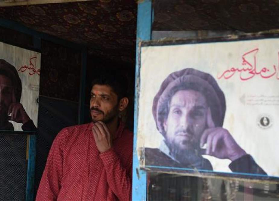 The file photo shows an Afghan shopkeeper standing next to the posters of Ahmad Shah Massoud, the largely revered leader also known as the Lion of Panjshir, in Kabul on May 6, 2018. (Photo by AFP)