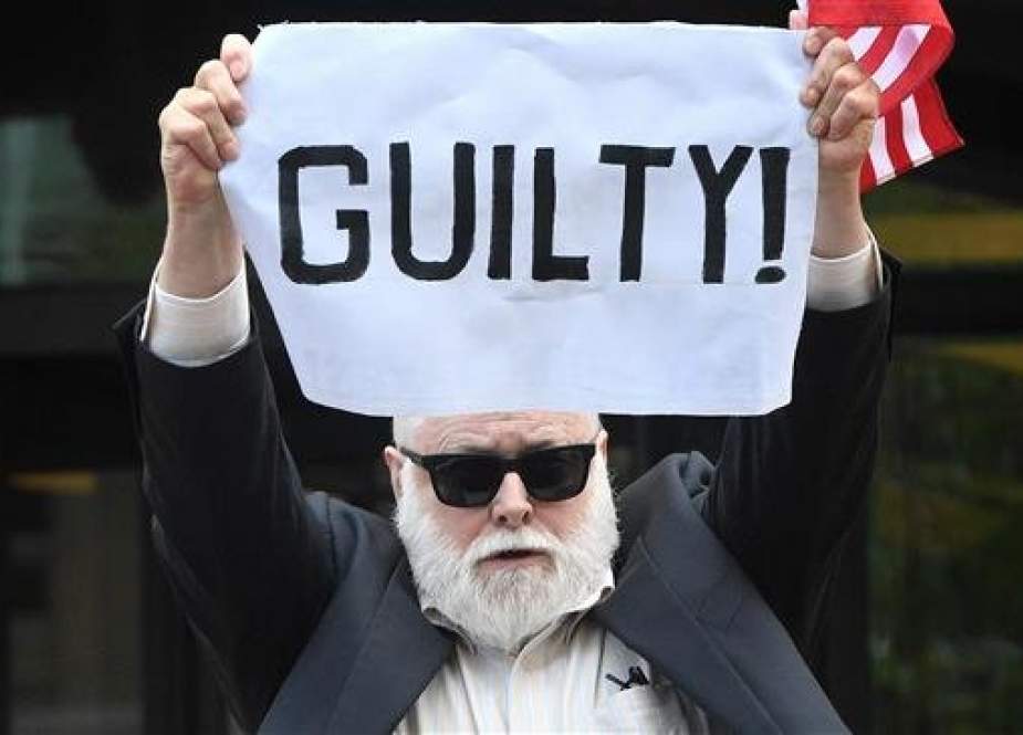 In this AFP file photo taken on August 21, 2018, a protester holds a sign outside the US Courthouse in Alexandria, Virginia, on the fourth day in the bank and tax fraud case against former Trump campaign manager Paul Manafort.