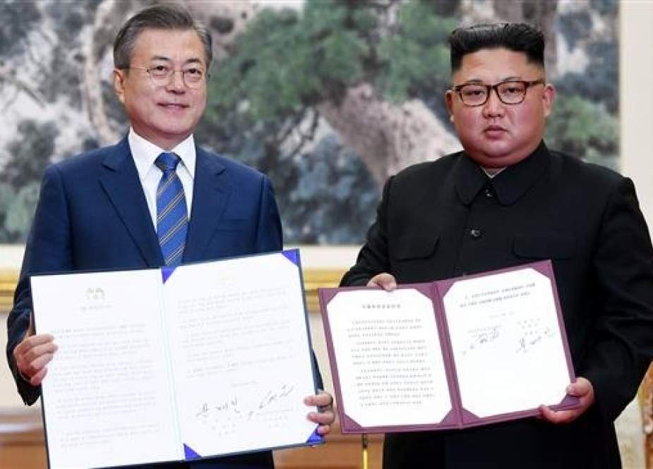 South Korean President Moon Jae-in (L) and North Korean leader Kim Jong-un pose for photographs with joint statements.jpg