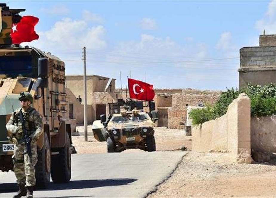 A handout picture released by the Turkish Armed Forces shows Turkish soldiers accompanied by armored vehicles patrolling between the city of Manbij in northern Syria and an area it controls after a 2016-2017 military incursion, on June 18, 2018. (Via AFP)