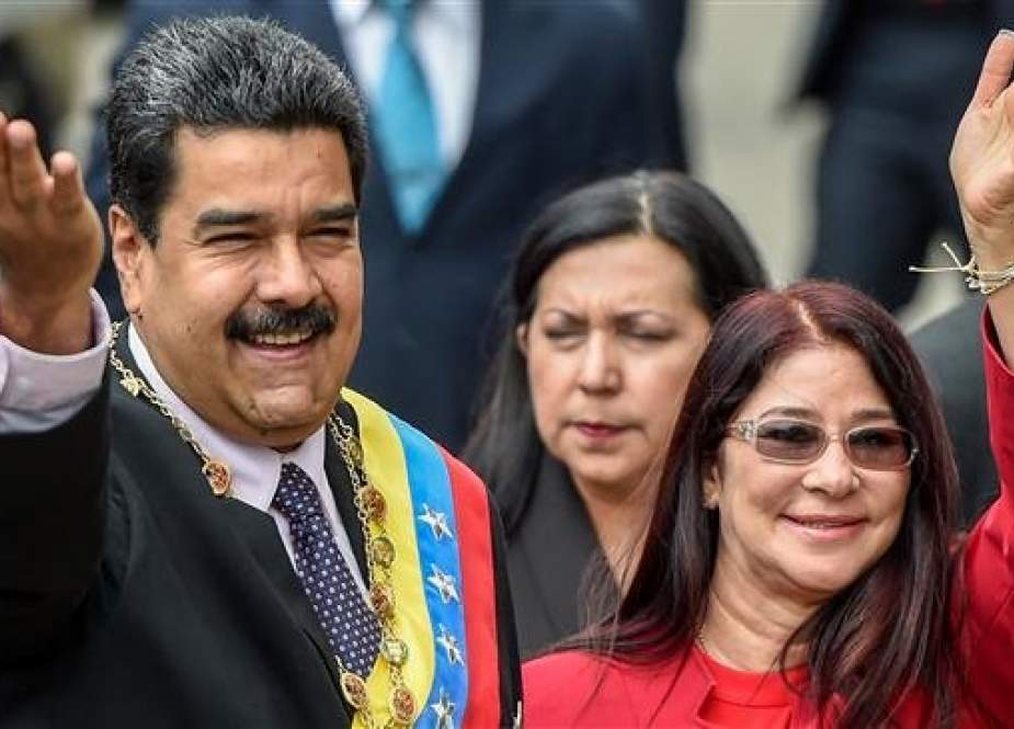 In this file photo taken on January 15, 2017, Venezuelan President Nicolas Maduro (L) and his wife, Cilia Flores, wave to supporters. (Photo by AFP)