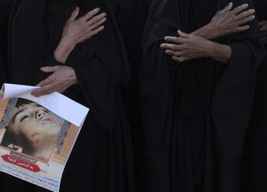 Black-clad Iranian women hold their hands on their chests in mourning, during a public funeral ceremony for the victims of a Saturday terrorist attack, in the city of Ahvaz, Iran, on September 24, 2018. The poster held by one of the women shows four-year-old Mohammad-Taha Eqdami, who was killed in the September 22 attack. (Photo by ISNA)