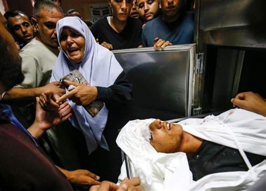 The aunt of slain 15-year-old Palestinian Ahmed Abu Habel killed during clashes with Israeli forces near a checkpoint in the Beit Hanoun area of the northern Gaza Strip reacts by his body at a hospital morgue in Beit Lahia in the northern Gaza Strip on October 3, 2018.