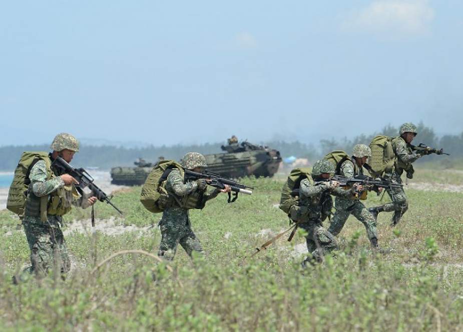 Philippine marines take position next to US marines Amphibious Assault Vehicles (AAV) during an amphibious landing exercise at the beach of the Philippine.