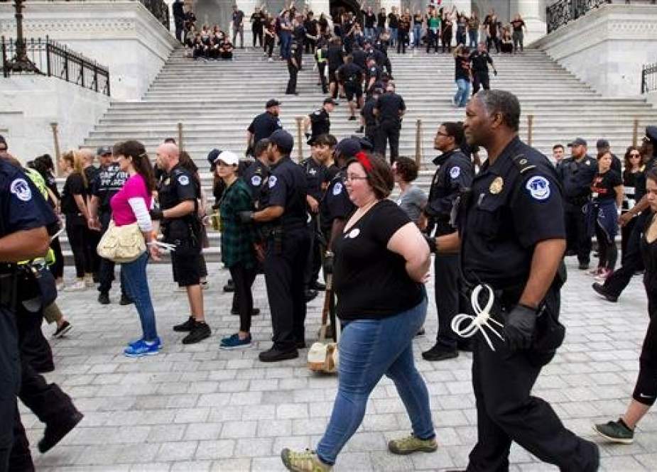Police arrest protesters opposed to US Supreme Court nominee Brett Kavanaugh participating in demo in Washington, DC, on October 6, 2018. (Photo by AFP)
