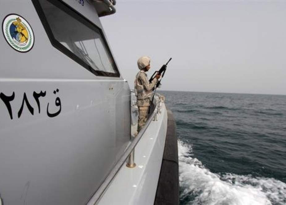 In this file photo, a Saudi border guard watches as he stands in a boat off the coast of the Red Sea on Saudi Arabia