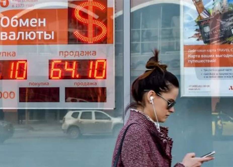 The file photo shows a woman walking past a currency exchange office in Moscow, Russia, April 10, 2018. (Photo by AFP)