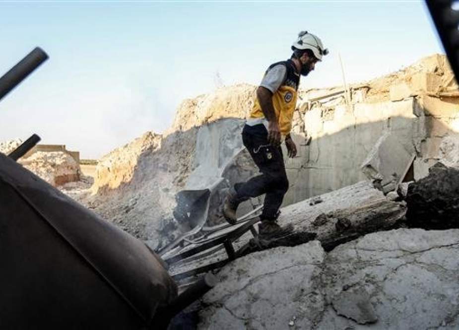 The picture taken on September 6, 2018 shows a member of the White Helmets walking through the wreckage of the group