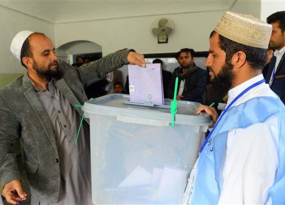 An Afghan voter casts his ballot at a polling center for the country