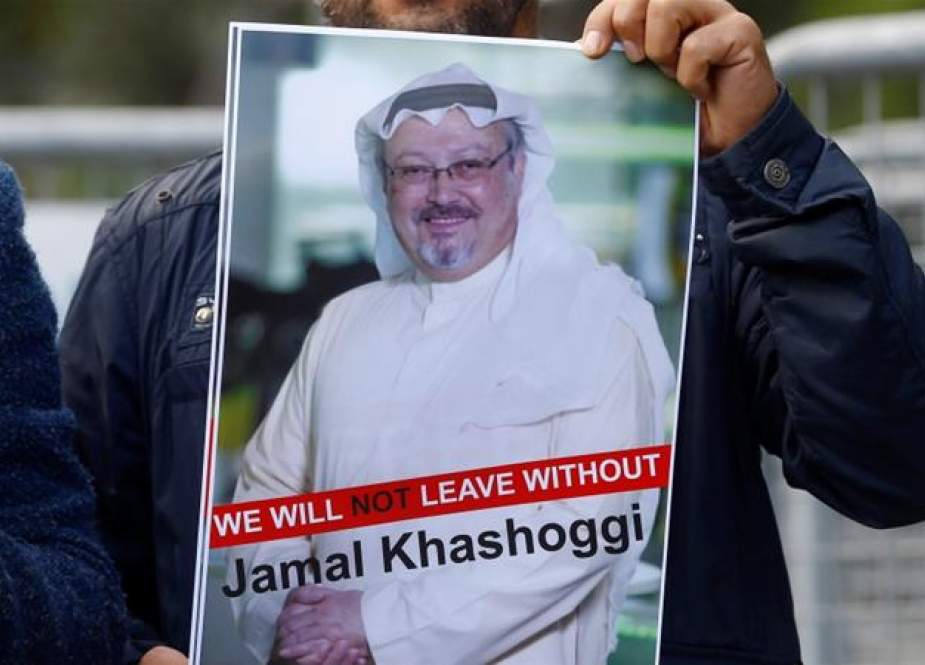 Demonstrator holds a picture of Jamal Khashoggi in front of Saudi Arabia