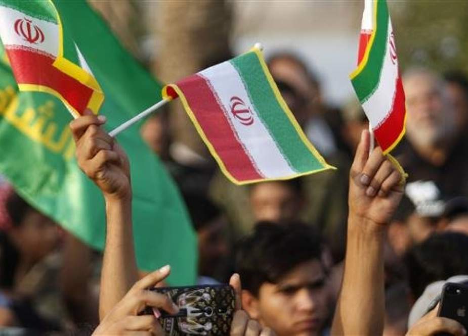 This September 15, 2018 file photo shows demonstrators waving flags of Iran and the Hashed al-Shaabi party (Popular Mobilization Forces) in the southern Iraqi city of Basra. (AFP photo)