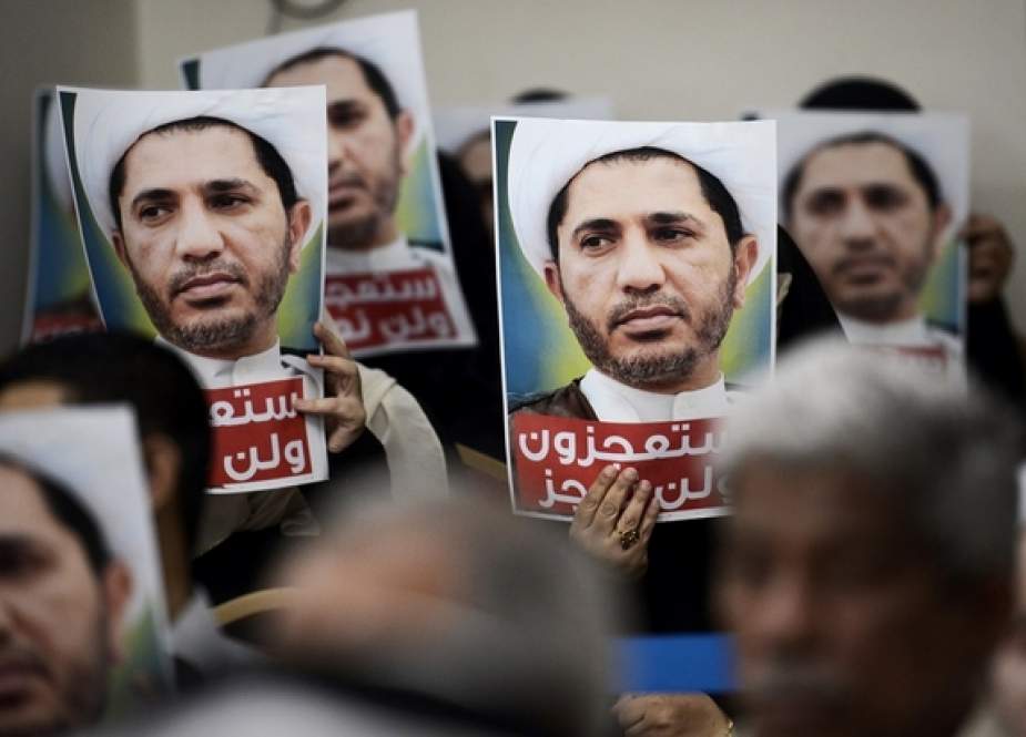 Bahraini men hold placards bearing the portrait of Sheikh Ali Salman.jpg