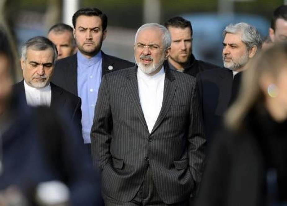 Iranian Foreign Minister Mohammad Javad Zarif (C) walks outside the hotel during a break after a bilateral meeting with former US Secretary of State John Kerry, in Lausanne, Switzerland, March 20, 2015.