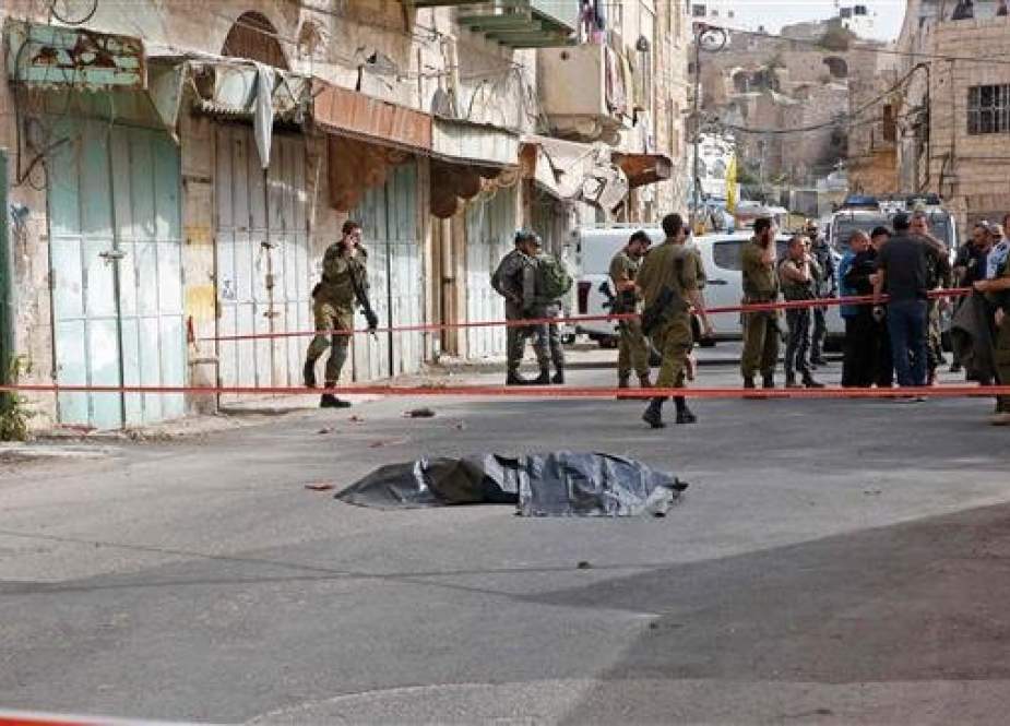 The file photo shows Israeli forces surrounding the body of a Palestinian in the occupied West Bank town of al-Khalil (Hebron) on October 22, 2018. (Photo by AFP)