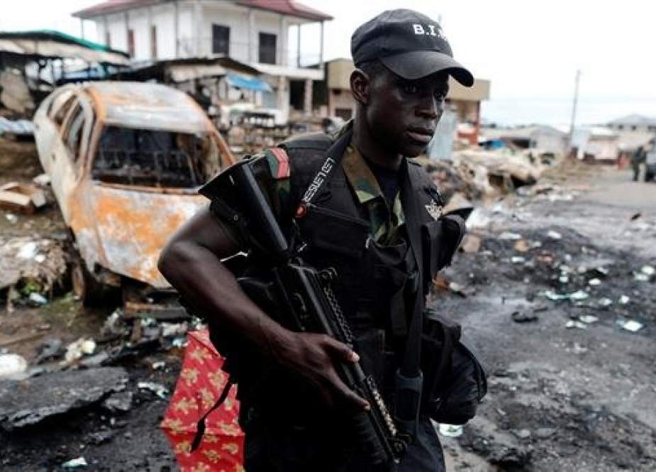 A Cameroonian soldier is seen walking past a burnt car while patrolling in the city of Buea, in the Anglophone Southwest Region, on October 4, 2018. (Photo by Reuters)