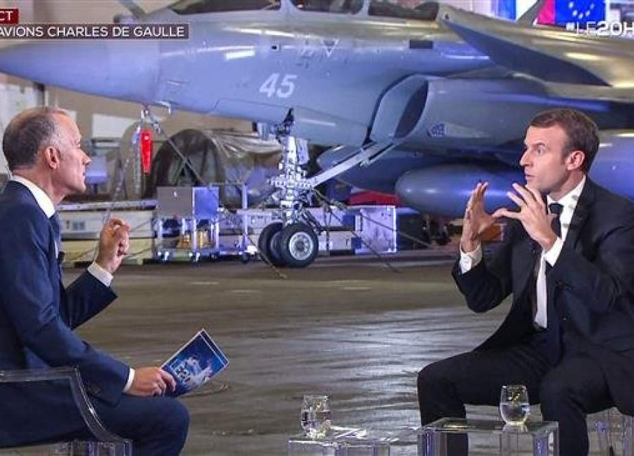 This video grab from footage taken and released by French television channel TF1 on November 14, 2018, shows French President Emmanuel Macron (R) speaking during a televised interview with French journalist Gilles Bouleau aboard the Charles de Gaulle aircraft carrier, off the coast of Toulon, southern France. (Photo by AFP)