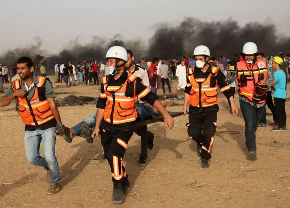 Palestinian paramedics carry away a protester injured during a demonstration along the Gaza Strip’s border, east of Khan Yunis.jpg