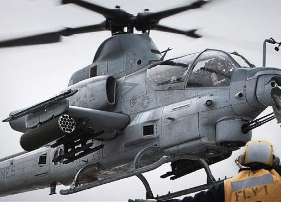 The undated photo, provided by US Marine Corps, shows a petty officer guiding an AH-1Z "Viper SuperCobra". (Via AFP)