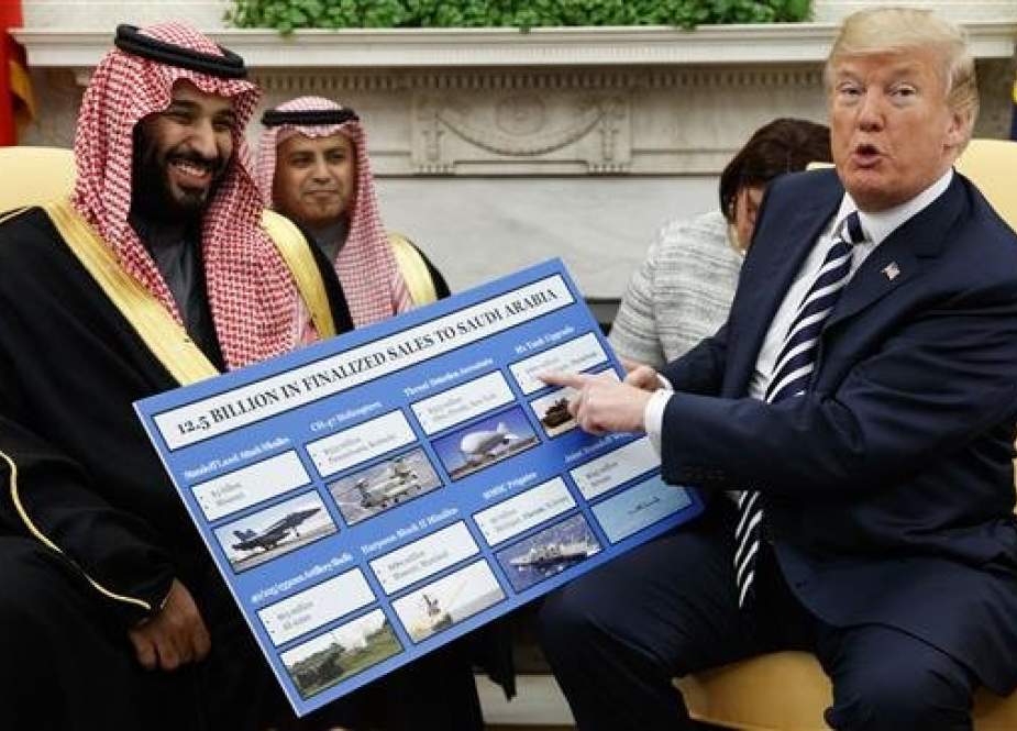 President Donald Trump (R) shows a chart highlighting arms sales to Saudi Arabia during a meeting with Saudi Crown Prince Mohammed bin Salman in the Oval Office of the White House, in Washington, on March 20, 2018. (Photo by AP)