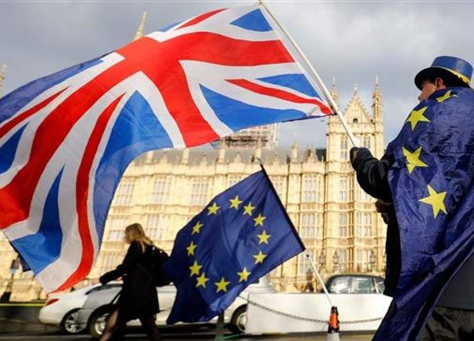 In this file photo taken on March 28, 2018 an anti-Brexit demonstrator waves a Union flag alongside a European Union flag outside the Houses of Parliament in London. (Photo by AFP)