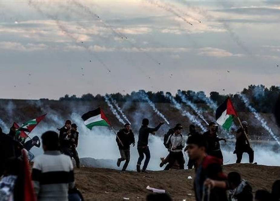 Palestinians react to tear gas fired by Israeli forces during a protest on November 23, 2018, on the eastern outskirts of Gaza City, near the border with the occupied territories. (Photo by AFP)