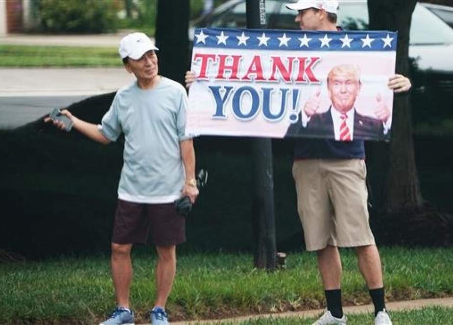 A Trump supporter holds up a placard as the motorcade carrying US President Donald Trump enters the Trump National Golf Club in Sterling, Virginia, on September 8, 2018. (AFP photo)