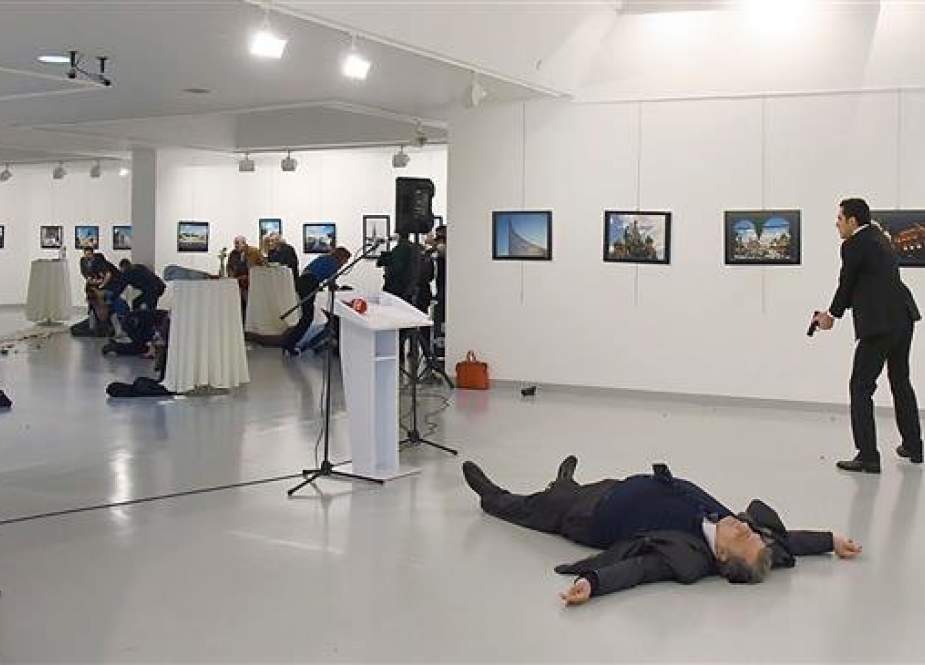 This photo taken on December 19, 2016, shows Andrey Karlov, the then Russian ambassador to Ankara, lying on the floor after being shot by Mevlut Mert Altintas (R) in an attack during a public event in Ankara, Turkey. (Photo by AFP)