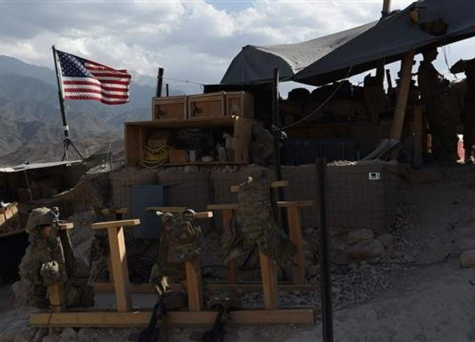 In this photo taken on July 7, 2018, US Army soldiers from NATO look on as a US flag flies in a checkpoint during a purported patrol against the Takfiri Daesh terrorist group at the Deh Bala district in the eastern province of Nangarhar, Afghanistan. (Photo by AFP)