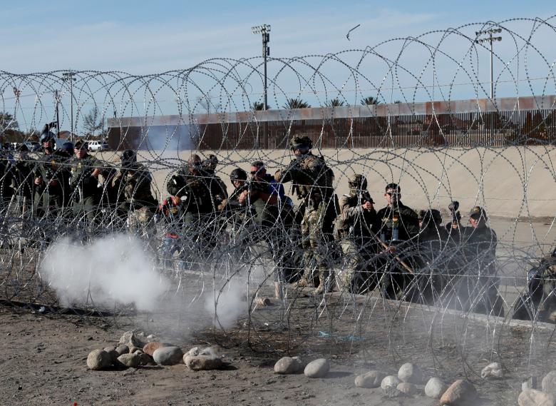 U.S. soldiers and U.S. border patrol fire tear gas towards migrants, part of a caravan of thousands traveling from Central America en route to the United States, from the U.S. side of the border fence between Mexico and the United States in Tijuana, Mexi