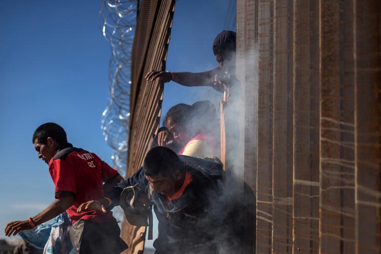 Migrants return to Mexico after being hit by tear gas by U.S. Customs and Border Protection (CBP) after attempting to illegally cross the border wall into the United States in Tijuana, Mexico November 25, 2018.