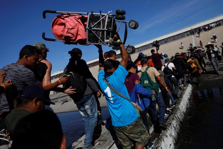 Migrants make their way across Tijuana river near the border wall between the U.S. and Mexico in Tijuana, Mexico November 25, 2018.
