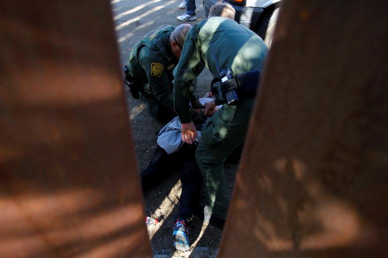 U.S. border patrol officers detain a group of migrants after they entered the United States illegally by jumping over the border fence between Mexico and the United States, from Tijuana, Mexico, November 25, 2018.