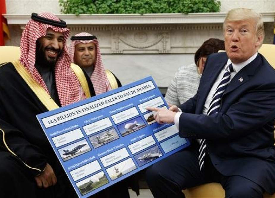 US President Donald Trump (R) holds a chart highlighting arms sales to Saudi Arabia during a meeting with Saudi Crown Prince Mohammed bin Salman in Washington on March 20, 2018. (Photo by AP)