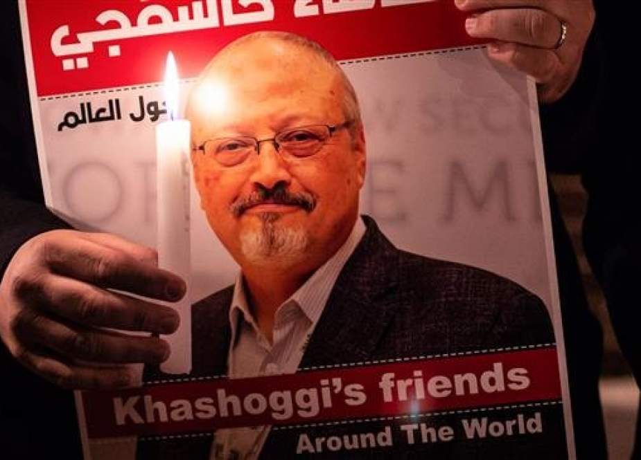 A demonstrator holds a poster picturing Saudi journalist Jamal Khashoggi and a lighted candle during a gathering outside the Saudi Arabia consulate in Istanbul, on October 25, 2018. (Photo by AFP)