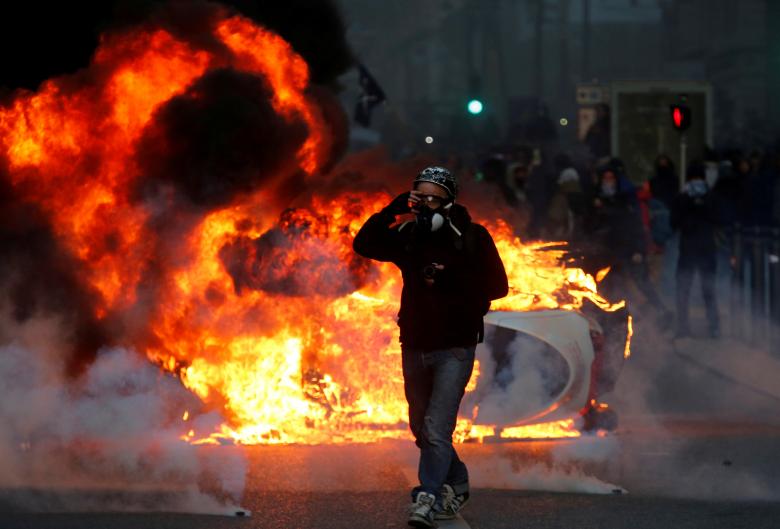 A car burns during clashes with police at a demonstration of the 