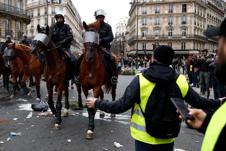 French mounted police advance during clashes with protesters wearing yellow vests at a demonstration during a national day of protest by the 
