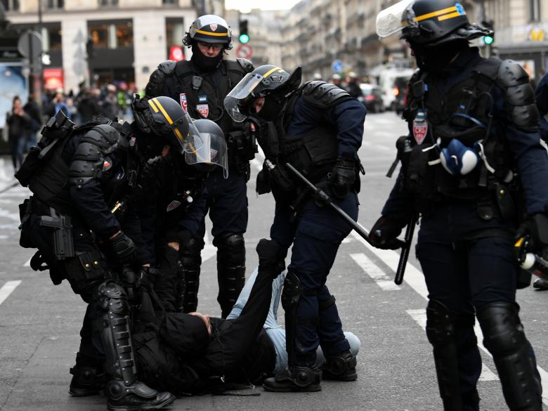 French CRS riot police apprehend a protester during clashes at a national day of protest by the 