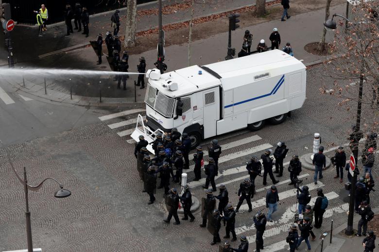 French riot police use a water cannon during clashes at a demonstration by the 