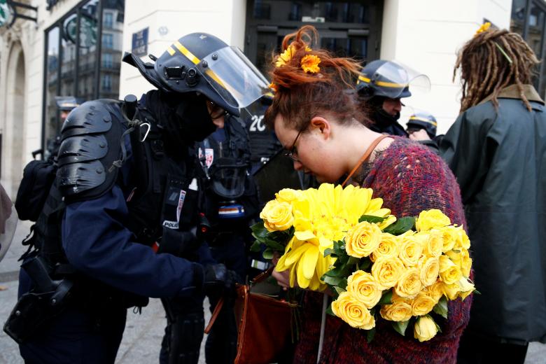 French CRS riot police check the bag of a woman during a national day of protest by the 