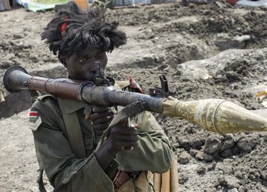A South Sudanese government soldier wearing a wig holds a rocket propelled grenade launcher while standing in a trench in the city of Malakal on October 16, 2016. (Photo by AP)