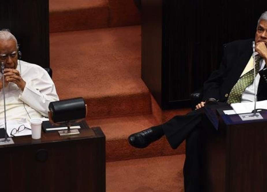 This file photo shows Sri Lanka’s then-ousted prime minister Ranil Wickremesinghe (R) and opposition leader R. Sampanthan (L) looking on at the parliament in Colombo, Sri Lanka, on November 30, 2018. (By AFP)