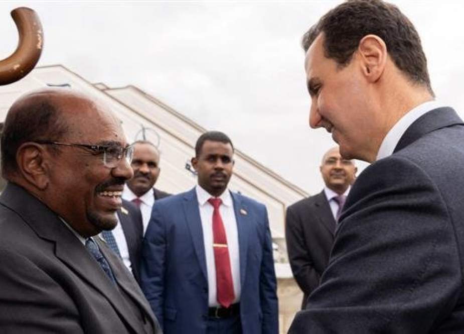 A handout picture released by the official Syrian Arab News Agency (SANA) on December 16, 2018 shows Syrian President Bashar al-Assad receiving his Sudanese counterpart Omar al-Bashir upon his arrival at the airport in the Syrian capital Damascus. (Photo by AFP)