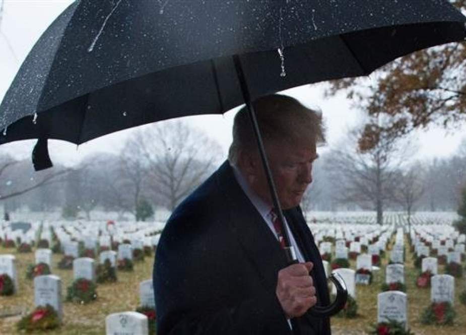 US President Donald Trump walks past tombstones on December 15, 2018 during an unscheduled visit to Arlington National Cemetery. (Photo by AFP)