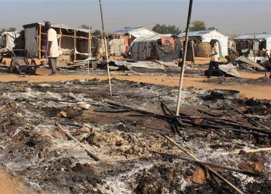 Residents walk past burnt houses following multiple attacks by Boko Haram Islamists at Dalori and other neighbouring villages outside the Borno state capital of Maiduguri, northeastern Nigeria, on November 1, 2018. (Photo by AFP)