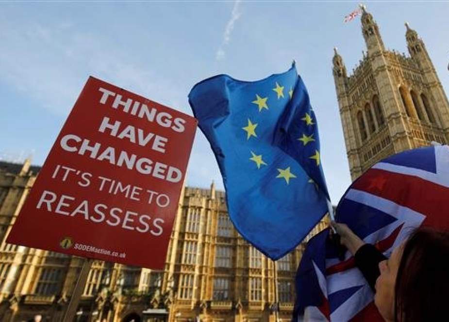 Anti-Brexit campaigners wave British and European Union flags outside the Houses of Parliament in central London, United Kingdom, on December 17, 2018. (Photo by AFP)