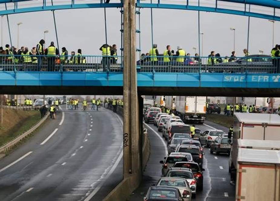 Yellow vest protesters stand on an overpass in Ifs, northwestern France.jpg